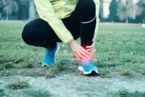 Woman holding her painful arthritic ankle
