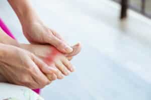Woman holds her painful arthritic big toe in Prescott, AZ